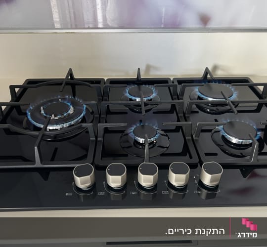 כיריים גז עם להבות כחולות במטבח מודרני